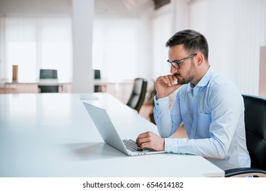 Handsome man working on project at modern office desk