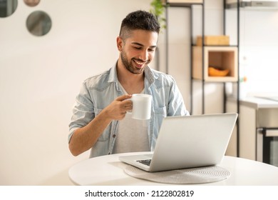 Handsome man working using computer laptop and drinking a cup of coffee at home office - Powered by Shutterstock