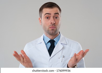 Handsome Mature Male Doctor Shrugging Lifting Shoulders On Grey Background. Expert Opinion. Mature Doctor Man Shrug Isolated On Grey Background