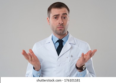 Handsome Mature Male Doctor Shrugging Lifting Shoulders On Grey Background. Mature Doctor Man Shrug Isolated On Grey Background