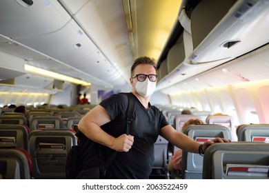 Handsome Mature Man Wearing Protection Face Mask During Traveling By An Airplane. Safety Transportation While Coronavirus Epidemic.