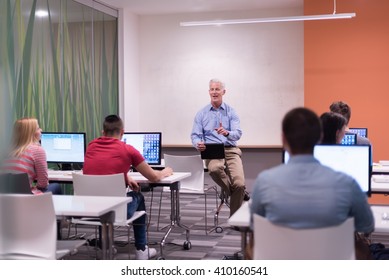 Handsome Mature Teacher And Students In Computer Lab Classroom