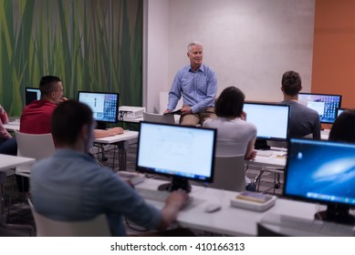 Handsome Mature Teacher And Students In Computer Lab Classroom