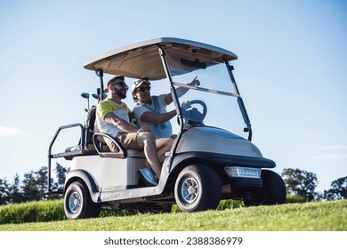 Handsome men are talking and smiling while driving a golf cart and searching for a golf hole - Powered by Shutterstock