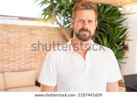 Handsome mid adult man smiling and looking at camera. Portrait of happy young casual man. Close up portrait of caucasian guy standing outdoor.