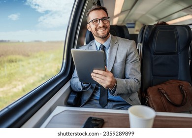 Handsome middle age businessman using his laptop computer while traveling with high-speed train. Modern and fast travel concept. - Powered by Shutterstock