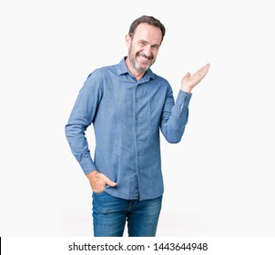 Handsome middle age elegant senior man over isolated background smiling cheerful presenting and pointing with palm of hand looking at the camera. - Powered by Shutterstock