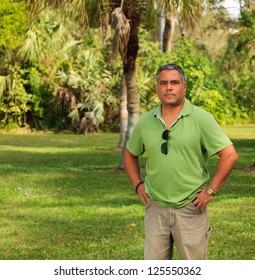 Handsome Middle Age Hispanic Man In A Park Setting.