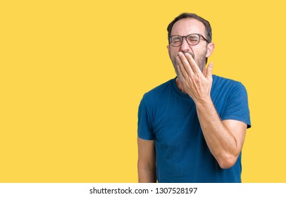 Handsome middle age hoary senior man wearin glasses over isolated background bored yawning tired covering mouth with hand. Restless and sleepiness.