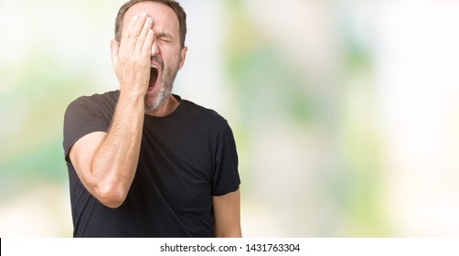 Handsome middle age hoary senior man over isolated background Yawning tired covering half face, eye and mouth with hand. Face hurts in pain.