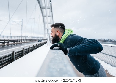 Handsome middle age man with a beard running and exercising outside on extremely cold and snowy day. Sport and fitness motivation theme. - Shutterstock ID 2204174873