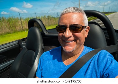 Handsome Middle Age Man Driving A Convertible Automobile On The Highway.