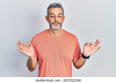 Handsome Middle Age Man With Grey Hair Wearing Casual T Shirt Relax And Smiling With Eyes Closed Doing Meditation Gesture With Fingers. Yoga Concept. 