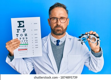 Handsome Middle Age Man Holding Optometry Glasses And Medical Exam Depressed And Worry For Distress, Crying Angry And Afraid. Sad Expression. 