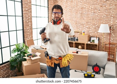 Handsome Middle Age Man Holding Screwdriver At New Home Pointing With Finger Up And Angry Expression, Showing No Gesture 