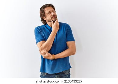 Handsome middle age man standing together over isolated background with hand on chin thinking about question, pensive expression. smiling with thoughtful face. doubt concept.  - Powered by Shutterstock