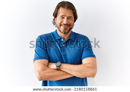 Handsome middle age man standing together over isolated background happy face smiling with crossed arms looking at the camera. positive person. 