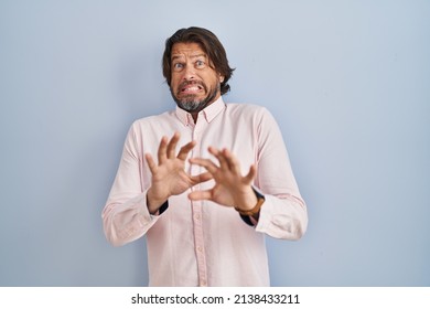 Handsome middle age man wearing elegant shirt background disgusted expression, displeased and fearful doing disgust face because aversion reaction.  - Shutterstock ID 2138433211