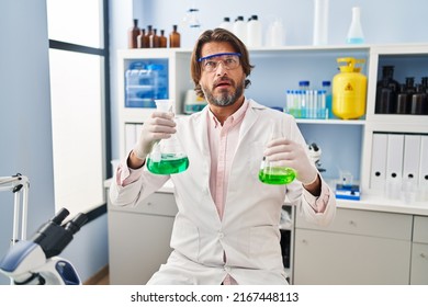 Handsome Middle Age Man Working At Scientist Laboratory Smiling Happy Pointing With Hand And Finger To The Side 