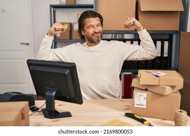 Handsome Middle Age Man Working At Small Business Ecommerce Showing Arms Muscles Smiling Proud. Fitness Concept. 