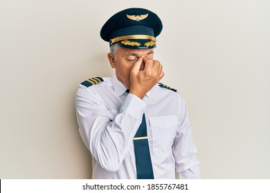 Handsome Middle Age Mature Man Wearing Airplane Pilot Uniform Tired Rubbing Nose And Eyes Feeling Fatigue And Headache. Stress And Frustration Concept. 