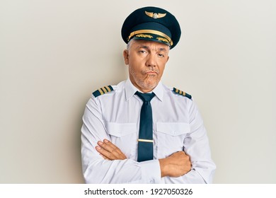 Handsome Middle Age Mature Man Wearing Airplane Pilot Uniform Looking Sleepy And Tired, Exhausted For Fatigue And Hangover, Lazy Eyes In The Morning. 