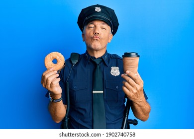 Handsome Middle Age Mature Police Man Eating Donut And Drinking Coffee Looking At The Camera Blowing A Kiss Being Lovely And Sexy. Love Expression. 