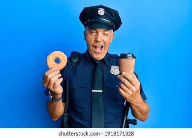 Handsome Middle Age Mature Police Man Eating Donut And Drinking Coffee Winking Looking At The Camera With Sexy Expression, Cheerful And Happy Face. 