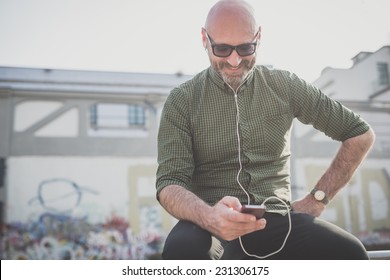 Handsome Middle Aged Man Listening To Music In The City