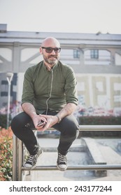 Handsome Middle Aged Man Listening To Music In The City