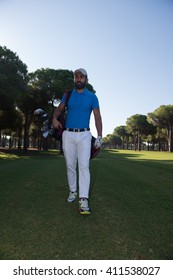 handsome middle eastern golf player carrying and bag  and walking at course on beautiful morning sunrise