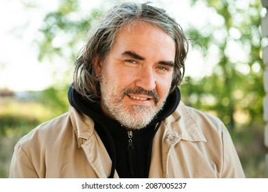 A Handsome Middle-aged Man With Long Hair And Beard Outside.