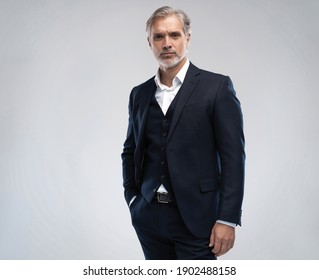 Handeiniger Mann mittleren Alters in Anzug auf grauem Hintergrund