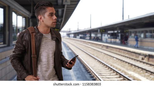 Handsome Millennial Latin Male At The Train Station Hailing A Ride