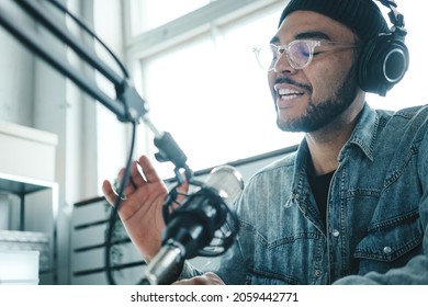 Schöner Mixed-Rennen-Content-Ersteller, der seine Audio-Show im gemütlichen Heimstudio mit professionellem Mikrofon und Laptop durchströmt