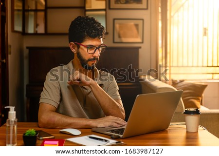 Handsome model with beard at his workplace. Home office concept.