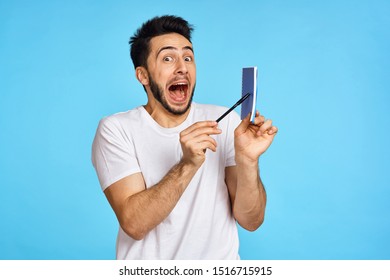  handsome model man looking at the camera with a notebook in his hands                              