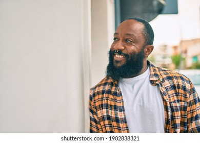 Handsome Modern African American Man With Beard Smiling Positive Leaning Over Wall