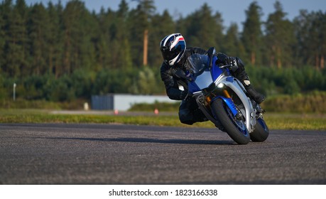 Handsome motorcyclist in black riding his super sport motorcycle.
european road racing championship. Unknown pilot. Racing MotoGP Team. Sport Biker Racing on Road
