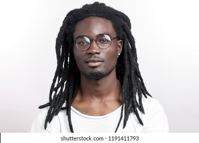 Handsome muscular black man with dreadlocks wearing glasses looking camera on white backgound