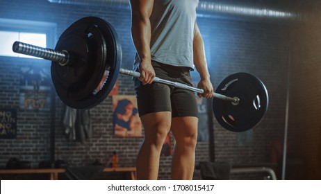 Handsome Muscular Man Does Overhead Deadlift with a Barbell in a Small Authentic Gym. Athletic Man Training His Arm Muscles and Exercises with Barbell. Workout in the Hardcore Gym.