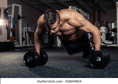 Handsome Muscular Man Doing Pushup Exercise With Dumbbell In A Crossfit Workout