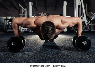 Handsome Muscular Man Doing Pushup Exercise With Dumbbell In A Crossfit Workout