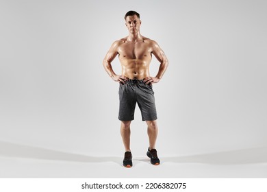 Handsome Muscular Man Holding Hands On Hip While Standing Against White Background