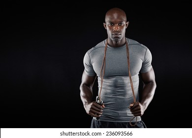 Handsome Muscular Man Posing With Jumping Rope On Black Background. African Fitness Model With Skipping Rope.