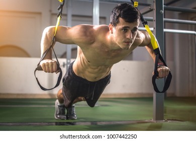 Handsome Muscular Man Training With Trx Fitness Straps In Outdoor Gym.