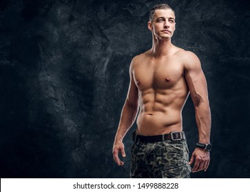 Handsome muscular man without t shirt is posing for photographer at dark photo studio. - Powered by Shutterstock