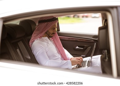 Handsome Muslim Man Working On A Computer While Traveling.