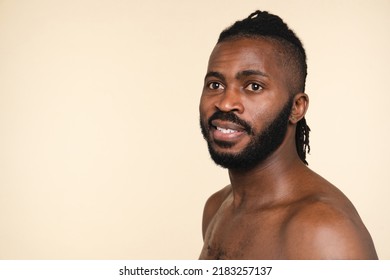 Handsome Naked Shirtless African-american Man With Dreadlocks And Beard Isolated In Beige Background. Male Beauty Skin Care Concept