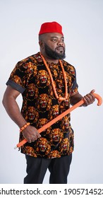 Handsome Nigerian man dressed in Igbo traditional attire and walking stick